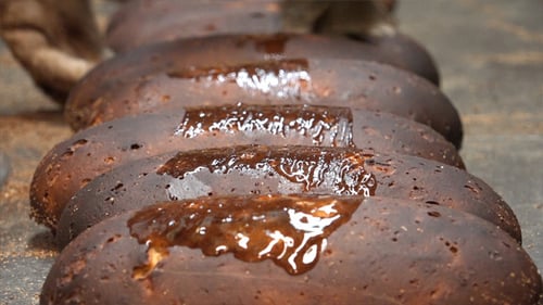 Dark Bread Being Brushed With Glossy Sauce