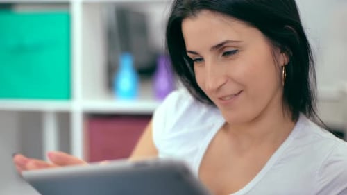 Smiling Woman Using Tablet Device Indoors