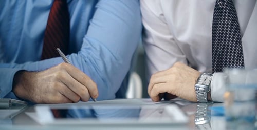Men Signing Business Deal in Modern Office