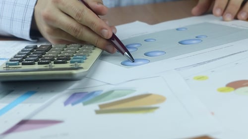 Calculator and Financials at Desk in Workplace