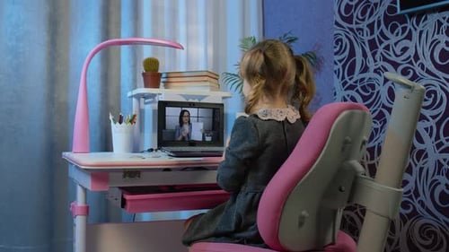 Child Girl Doing School Homework on Laptop Computer at Home with Woman Teacher Distance Education