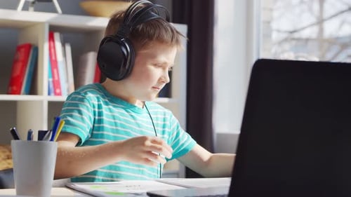 Young Boy Studying and Highlighting Homework at Home
