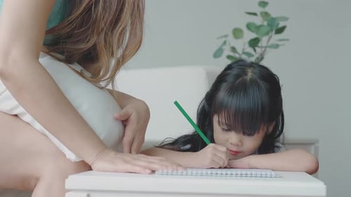 Young Girl Drawing with Adult Woman Indoors