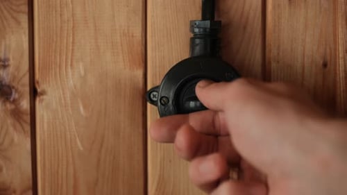 Interruptor de cor preta retrô em ação Interruptor de luz vintage ligado manualmente na parede de madeira