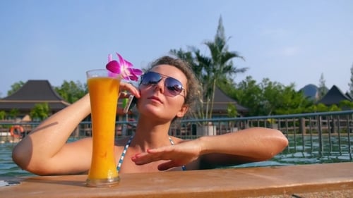 Young Woman Using Cell Phone In Pool