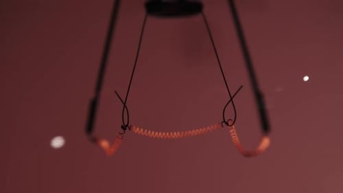 Das Wolframfilament in einer Glaslampe Nahaufnahme in Zeitlupe auf rotem Hintergrund