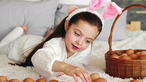 Cute Girl Plays with Easter Eggs at Home