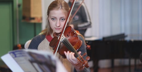 Young Woman Plays Violin in Music Classroom