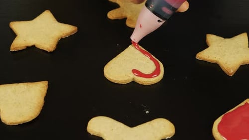Decorating gingerbread heart cookie for St. Valentine's Day