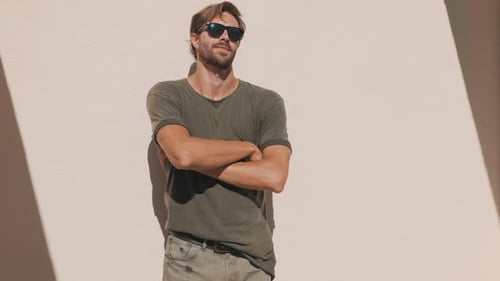 Stylish Young Man Posing Casually Against Wall