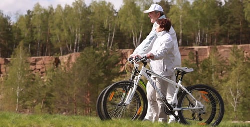 Active Senior Couple Biking on Park Trail