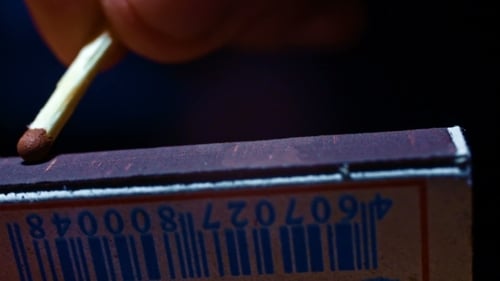 Macro Shot of Match Igniting with Sparks and Smoke