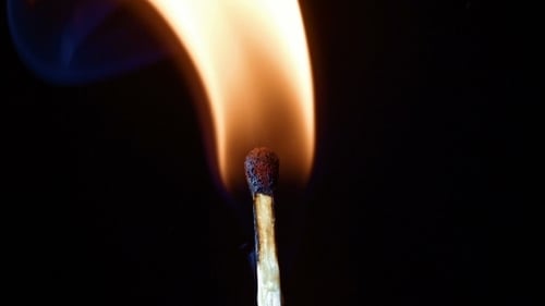 Match Ignites and Burns in Slow Motion on Black Background
