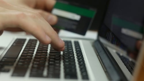 Typing on Laptop with Credit Card in Hand