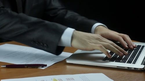 Adult Hands Typing on Laptop After Signing Document