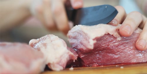 Man Cut Meat for Steaks