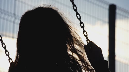 Silhouette of a Woman on a Swing Set