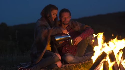 Romantic Couple Around Campfire at Night