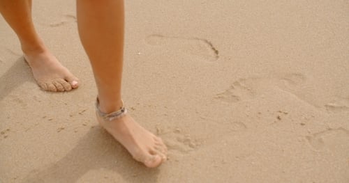 Bare Feet Coated In Sand Walking On Beach