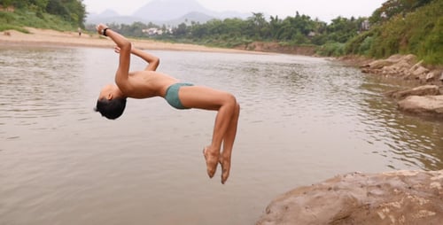 Young Man Doing A Back Flip Into River