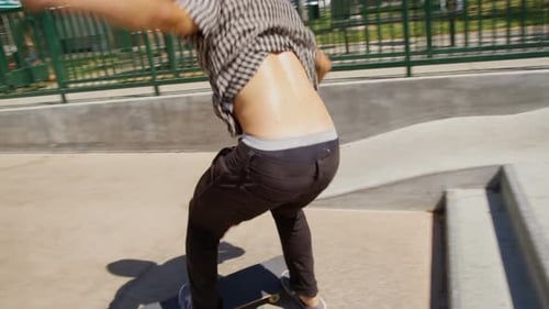 Young Man Falls While Skateboarding at Skatepark