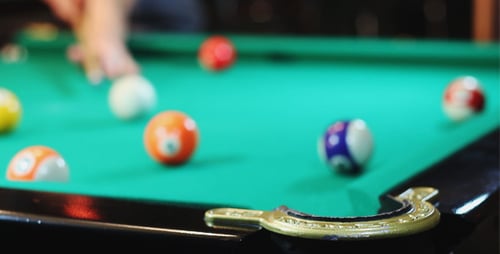 Cue Ball Hitting Orange Billiards Ball on Table