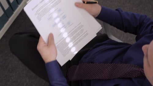 Man Reviews Financial Reports in Office Setting