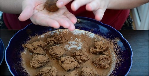 Hands Forming Chocolate Balls on Decorative Plate