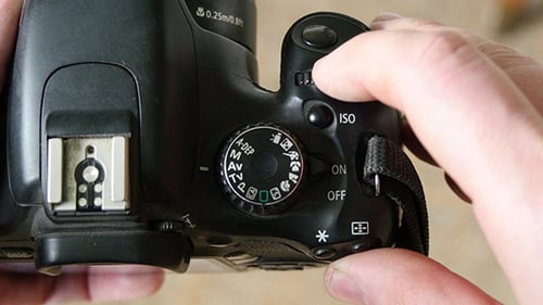 Hands Adjusting Settings on a DSLR Camera