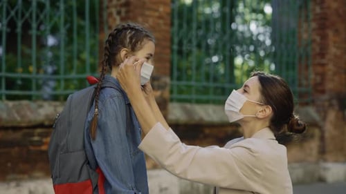 Mother Carrying About Her Kid and Wearing the Surgery Mask to Her Daughter on the Street Before