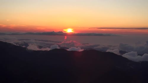 Coucher de soleil depuis le sommet brumeux et nuageux de la montagne
