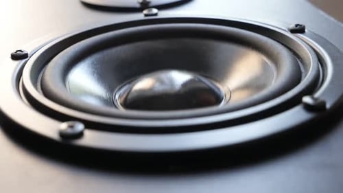 Speaker cone moves slowly in close up shot