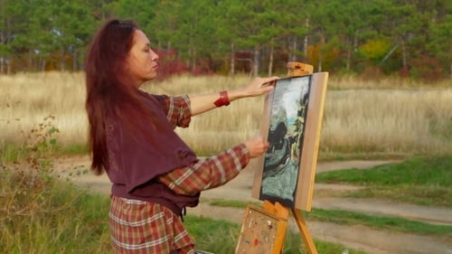Woman Painting a Picture on Easel in Nature