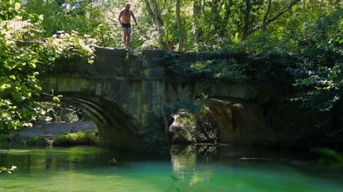 Homme sautant dans la rivière