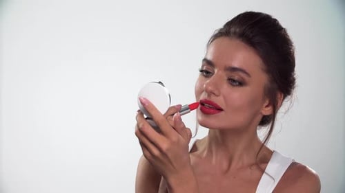 Woman Applying Red Lipstick in Mirror