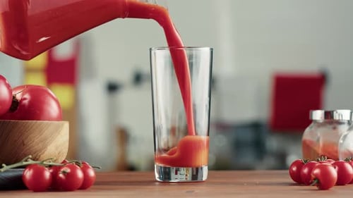 Femme versant du jus de tomate Jus de légumes rouges frais sur la table de la cuisine Vitamine C italienne et espagnole