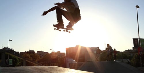 Young Adults Skateboarding at Skate Park at Sunset
