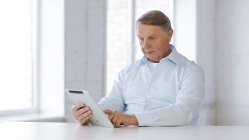 Senior Man Using Tablet in Bright Room