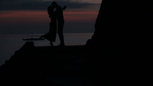 Romantic Couple Embrace at Sunset Over the Ocean