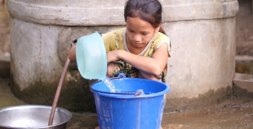 Pobre niña recibiendo agua