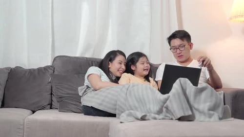 Happy Family Relaxing Together on Couch at Home