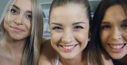 Three Young Women Smiling and Laughing Together Indoors