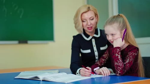 Girl Studying with Teacher in Classroom