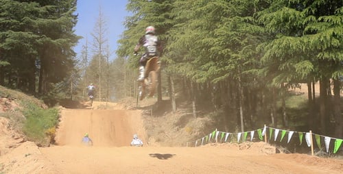 Motocross Riders Jumping on Dirt Track