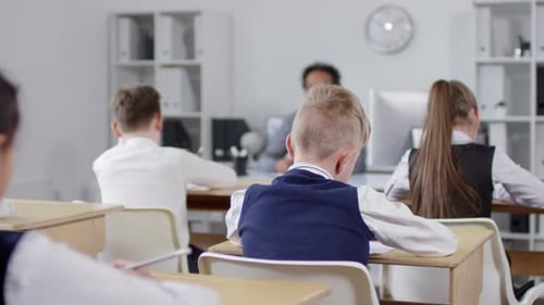 Les élèves du primaire dessinent avec des crayons lors d'une leçon d'art
