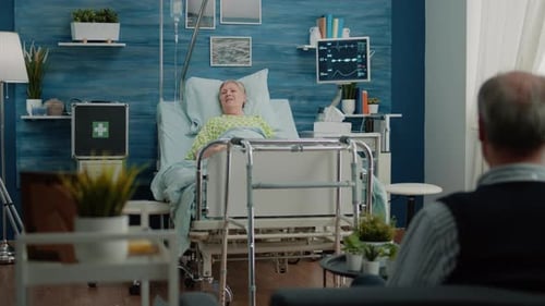 Senior Patient in Hospital Bed Receiving Medical Visit