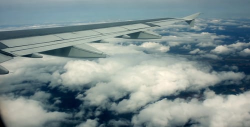 Airplane Wing View Above Fluffy White Clouds