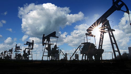 Oil Pump Jacks Silhouetted Against Blue Sky