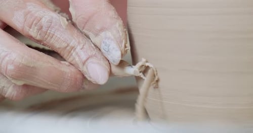 Potière assise et fabrique une tasse sur la roue à poterie. Femme fabriquant un Item en céramique. Poterie