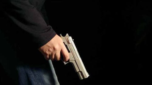 Hombre caminando lento con un arma en la mano